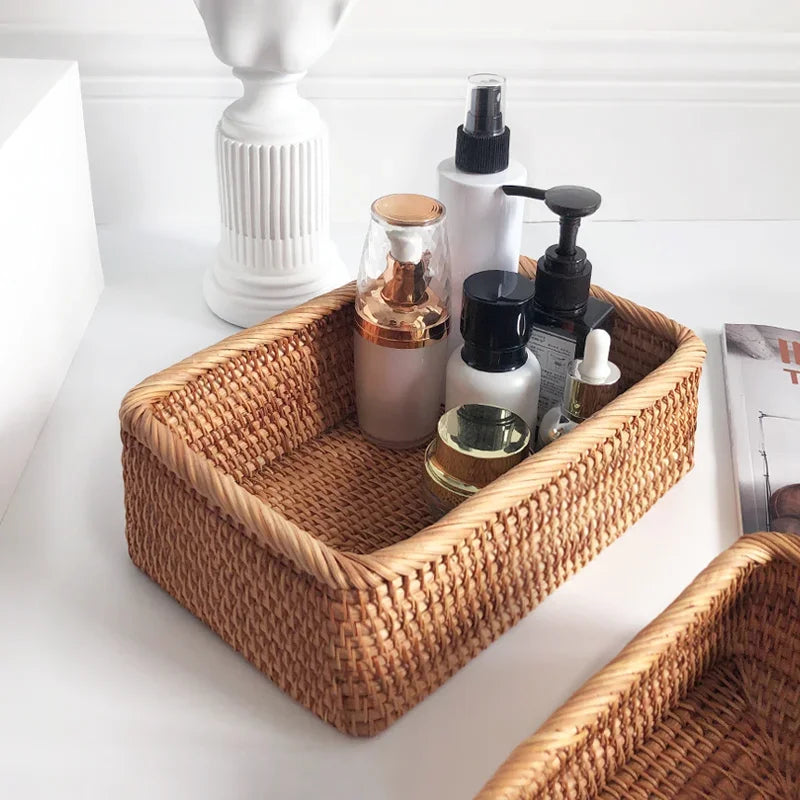 Hand-woven rattan wicker basket by eprolo, filled with fruit, tea, snacks, and bread on a neutral background.