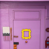 Purple wooden door-shaped key holder by eprolo with hanging hooks, designed as a charming wall-mounted wooden key hanger.
