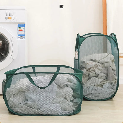 Green mesh laundry hampers filled with clothes beside a washing machine