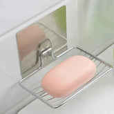 Stainless steel soap holder with pink bar soap mounted on bathroom tile wall