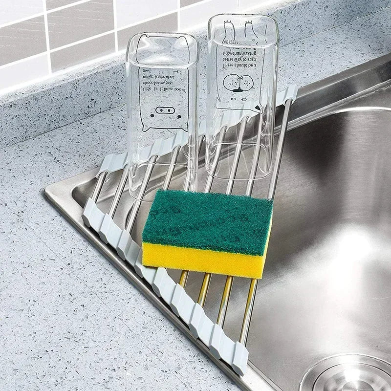Foldable stainless steel triangle dish rack by eprolo with drainboard, kitchen sink corner sponge organizer in a modern kitchen.