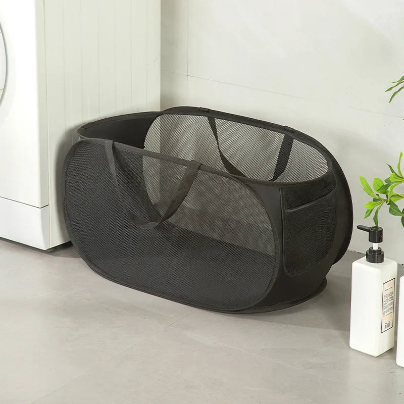 Black mesh laundry hamper with handles, ideal for home laundry organization near washing machine